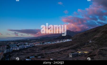 Spanien, Teneriffa, Rote nachglimmen Himmel nach Sonnenuntergang über den Bergen der Insel neben Los Christianos tourist resort, Luftaufnahme vor Ort Stockfoto