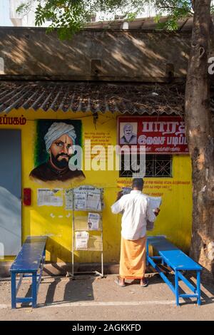 Rückansicht des Menschen lesen Zeitung am Kiosk in Puducherry, Tamil Nadu, Indien Stockfoto