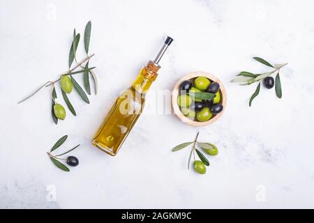 Kreative flach mit einer Flasche Olivenöl, Oliven und Blätter Stockfoto