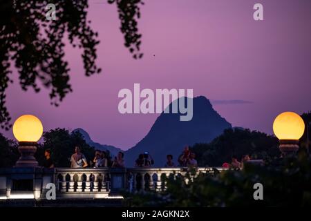 Guilin, China - August 2019: Menschen auf der Straße Brücke über die Mündung des Rong und Shan Seen bei Nacht, Guilin, Guangxi Provinz Stockfoto