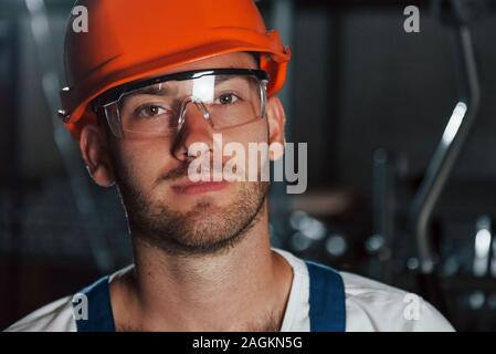 Nahaufnahme Foto. Portrait von Ingenieur in metallurgischen Werk in Schutzhelm und Brillen Stockfoto