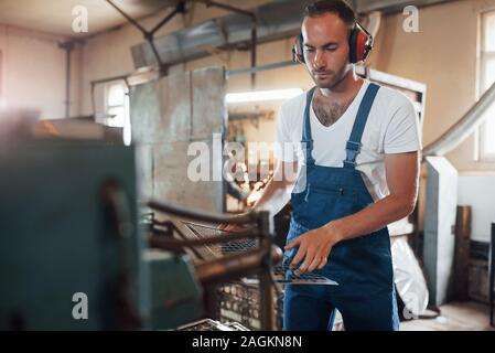 Wenig Metallkonstruktion. Mann in Uniform Werke auf die Produktion. Die industrielle moderne Technologie Stockfoto