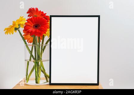 Mock up weißen Rahmen und Bündel von hellen Gerbera Blumen Stockfoto