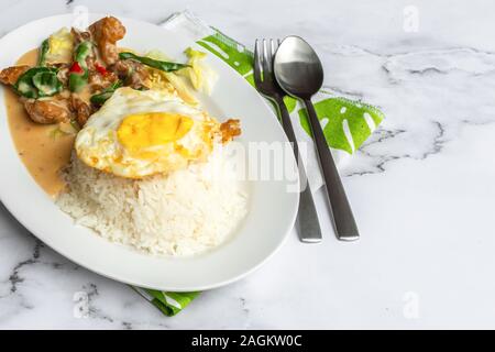 Cremige gesalzene Ei gebratenes Huhn mit Reis und Ei. Asien Essen auf dem Tisch. Stockfoto