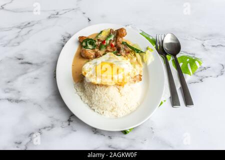 Cremige gesalzene Ei gebratenes Huhn mit Reis und Ei. Asien Essen auf dem Tisch. Stockfoto