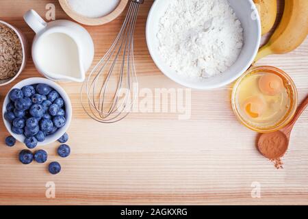 Zutaten für blueberry muffins Vorbereitung auf Holztisch, Ansicht von oben. Stockfoto