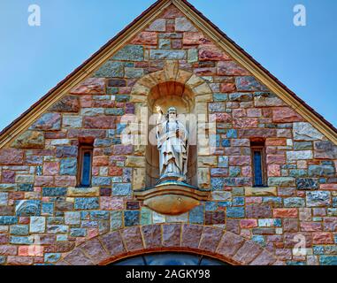 Eine Statue des Heiligen Apostels Thomas mit Blick auf den Eingang der katholischen Kirche mit 530 Elizabeth Street Ann Arbor, Michigan. Stockfoto