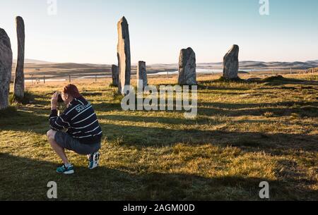 Fotograf, der Callanish 1 neolithische Stehsteine im Morgengrauen, Callanish, Isle of Lewis, Outer Hebrides, Schottland, schießt Stockfoto