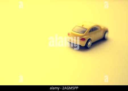 Unfocused gelbes Spielzeugauto auf den gelben Raum. Stockfoto
