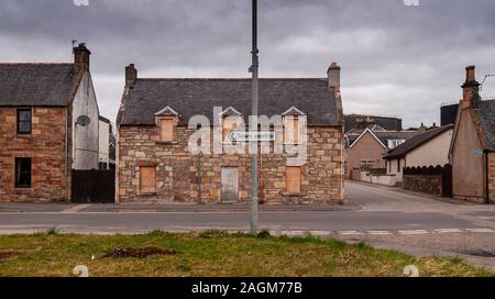 Invergordon, Schottland, UK - 28. März 2011: Ein traditionelles Landhaus aus Stein ist mit Brettern vernagelt und in der Stadt Invergordon im Easter Ross aufgegeben. Stockfoto