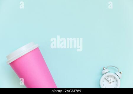 Einfach flach Design rosa Papier Kaffeetasse und Wecker auf Blau Pastell bunten Hintergrund isoliert. Takeaway trinken Frühstück trinken. Guten Morgen aufwachen wach Konzept. Ansicht von oben kopieren Raum Stockfoto