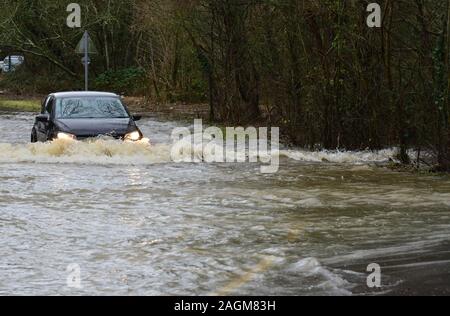 Horley, Surrey/Vereinigtes Königreich - 20. Dezember 2019: Der Fluss Maulwurf seine Ufer überflutet hat, Autos versuchen, durch das Hochwasser zu fahren Stockfoto