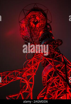London, England, Großbritannien - November 21, 2019: Die ArcelorMittal Orbit Turm wirft einen roten Glanz auf einem nebligen Nacht im Londoner Olympic Park. Stockfoto