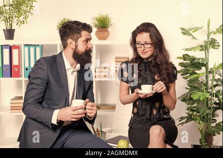Büro Gerüchte. Büro Kaffee. Paar Kollegen Kaffeepause entspannen. Teilen Kaffee mit Kollegen. Flirten Kollegen. Mann und attraktive Frau mit Bart. Mann und Frau Gespräch Kaffee Zeit. Stockfoto