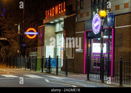 London, England, UK - 18. November 2019: Shadwell Station an der East London Line der oberirdischen Leuchtet nachts auf Kabel-Straße im Osten. Stockfoto