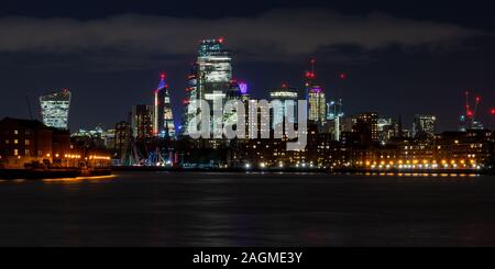 London, England, UK - 18. November 2019: Wolkenkratzer der Skyline der Stadt London bei Nacht entlang der Themse beleuchtet werden. Stockfoto