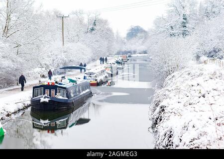 Badewanne, Großbritannien - 19 JAN: Wanderer pass angelegten Boote auf dem Kennet und Avon Kanal im Schnee am 19. Jan 2013. Die Boote bleiben den ganzen Winter günstig Stockfoto