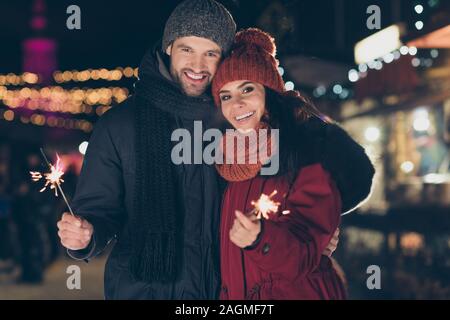 Porträt Seiner er ihr, daß sie schöne attraktive Bezaubernd, charmantes, cute aufgeregt positive Heiter Heiter froh Paar tragen warmen Outfit holding Bengal sticks Stockfoto