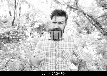 Hey, sieh. Bärtiger Mann Zeigefinger vor ihm auf natürliche Landschaft. Brutale hipster zeigt mit dem Zeigefinger auf Kamera. Caucasain Kerl zeigt auf etwas. So zeigen Geste. Stockfoto