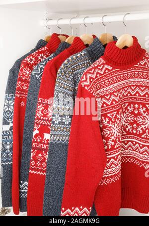 Verschiedene gestrickt Weihnachten rollkragen pullover oder Pullis mit Nordic geometrische Verzierung auf Kleiderbügel im Schrank Rack Stockfoto