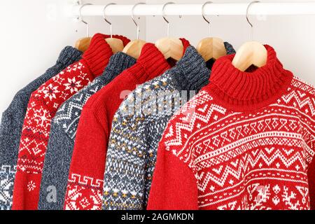 Verschiedene gestrickt Weihnachten rollkragen pullover oder Pullis mit Nordic geometrische Verzierung auf Kleiderbügel im Schrank Rack Stockfoto