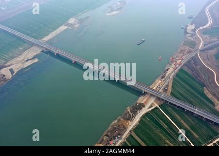 Jingmen. 20 Dez, 2019. Luftbild am Dez. 20, 2019 zeigt die Brücke des Flusses Hanjiang Zaoyang-Qianjiang Expressway in der zentralen Provinz Hubei China übernommen. Der Bau der 244 km langen Zaoyang-Qianjiang Expressway ist bald abgeschlossen, mit seiner Geschwindigkeit ausgelegt auf 100 Kilometer pro Stunde. Die Schnellstraße wird verkürzt sich die Reisezeit zwischen nördlichen und südlichen Hubei Hubei. Credit: Jin Liangkuai/Xinhua/Alamy leben Nachrichten Stockfoto