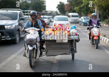 19. Oktober 2019, Thailand, Chiang Mai: eine Straße Hawker sitzt auf einem Motorrad neben seiner Güter und wartet an einer Ampel im Stau. Foto: Sebastian Kahnert/dpa-Zentralbild Stockfoto