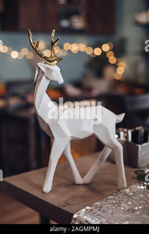 Weiße Hirsche Figur auf dem festlichen Tisch im Zimmer Stockfoto