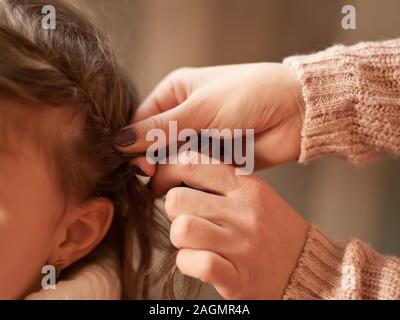 Mutter geflochtenen Zöpfen ihre Tochter Stockfoto