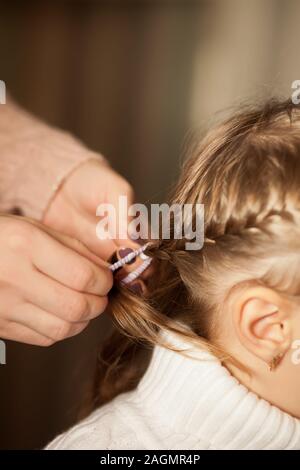 Mutter geflochtenen Zöpfen ihre Tochter Stockfoto