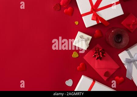 Geschenkboxen, rotes Papier Umschlag und roten Herzen auf rotem Hintergrund Stockfoto