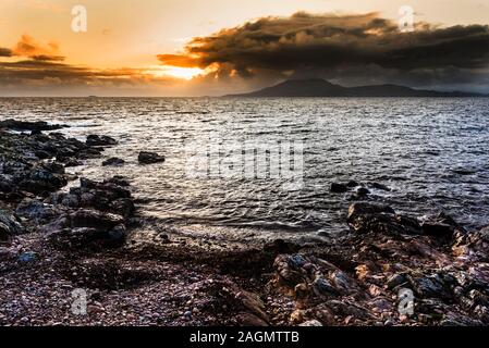 Blick über eine turbulente Meer bei Sonnenuntergang in Richtung Insel Clare von Roonagh Pier, westlich von Louisburg, County Mayo, Irland Stockfoto