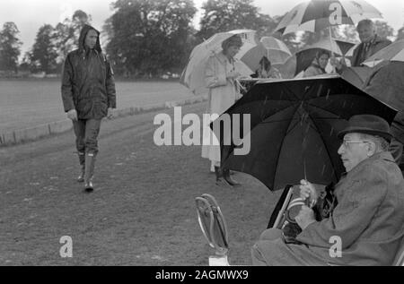 Schlechtes Wetter UK 80er Jahre Menschen im Cowdray Park Polo Club 1981 immer nass Alfresco Picknick während der Mittagspause England. HOMER SYKES Stockfoto