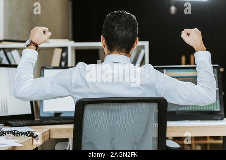 Zurück Blick auf rassische Bi - Händler zeigen ja Geste und Sitzen am Tisch Stockfoto