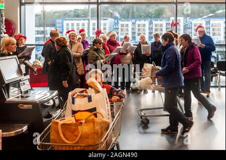 Bantry, West Cork, Irland. 20 Dez, 2019. Bantry Gemeinschaft Chor statt eine improvisierte Performance in einem Supermarkt in Bantry heute. Sie verbrachten Zeit zu Fuß rund um die Shop unterhaltsam die Käufer durch singen Weihnachtslieder. Credit: Andy Gibson/Alamy Leben Nachrichten. Stockfoto