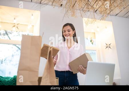 Low Angle eine schöne positive Frau mit Geschenken Stockfoto