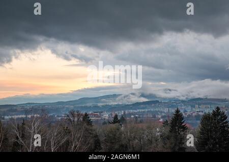 Schöne dramatischer Sonnenuntergang am Abend über die Stadt Banska Bystrica, Slowakei, Central Europe. Dunkler Himmel. Tag und Nacht. Stockfoto