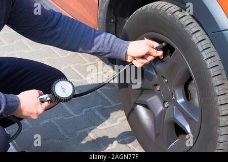 Car Service. Überprüft Druck in Autoreifen. Hand auf Auto reifen Ventil.  Automobil Wartungskonzept Stockfotografie - Alamy