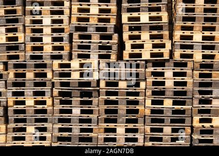 Paletten Hintergrund. Stapel von rauen Holzpaletten im Lager in der industriellen Hof. Fracht- und Versandkosten Konzept. Stockfoto