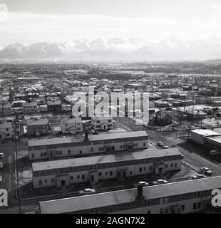 1960, historische, Luftaufnahme über dem Gehäuse in Anchorage mit der Chugach Berge in der Ferne, Anchorage, Alaska, USA. Stockfoto