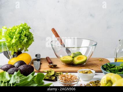 Hälften der Avocado in einem Glasgefäß auf dem Küchentisch. guacomole Zutaten. Kochen gesund essen konzept mit Platz für Text. Stockfoto