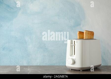 Toaster mit Brotscheiben auf blauem Hintergrund, Platz für Text Stockfoto