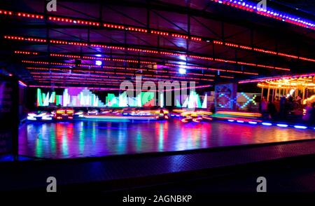 Beleuchtung Armaturenbrett um aus mehreren Dodgem Autos wie die Leute Spaß haben, einander anrempeln und laufen im Kreis herum. Stockfoto