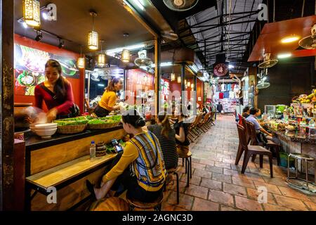 Junge Kambodschaner beim Mittagessen in einem Café auf dem Russischen Markt, Phnom Penh, Kambodscha. Stockfoto