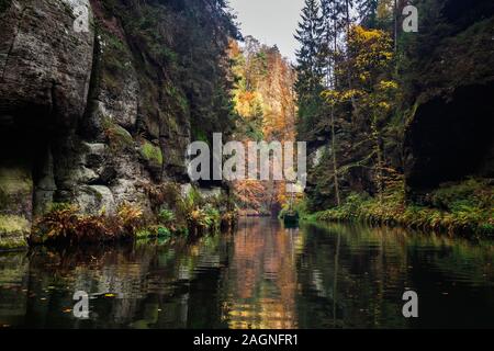 Fluss mit Herbstlaub und Felsbrocken auf dem Fluss Kamenice in der Böhmischen Schweiz. In der Nähe der wilden Schlucht. Stockfoto