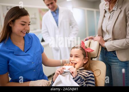 Junge weibliche Patienten Zahnarzt Schokolade essen Stockfoto