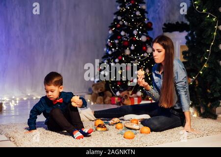 Mama und Junge öffnen Weihnachtsgeschenke Weihnachten Neujahr Stockfoto