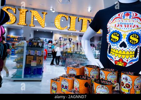 Innenaufnahmen von einem großen Sin City Schild und einem Schädel-T-Shirt und Tassen, die in einem Souvenirladen in den Forum-Shops, Las Vegas, Nevada, USA ausgestellt sind Stockfoto