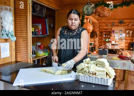 Native junge Frau schneiden traditionelle bannock Brot, Northern Quebec, Kanada Stockfoto