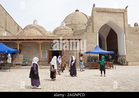 Frauen in der Tracht am Eingang des gewölbten Basare, Altstadt, Provinz Buxoro Buchara, Usbekistan Stockfoto